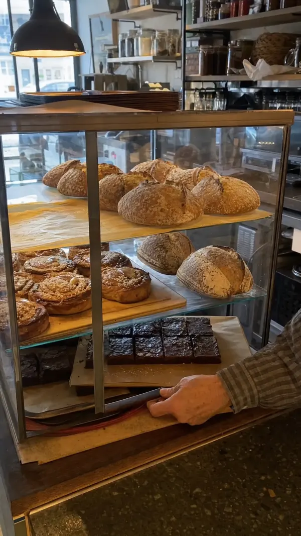 The glass counter filled with sourdough loaves, cinnamon buns and brownies