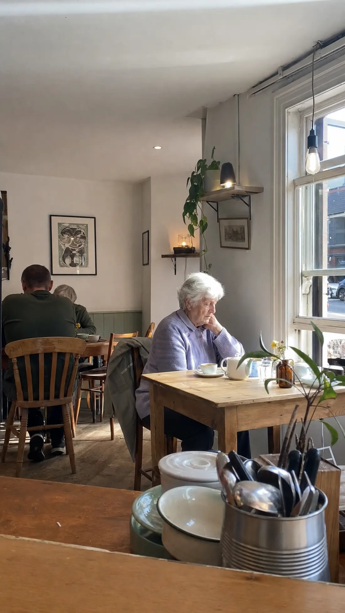 Mavis, in her lilac cardigan, at her usual table by the café window